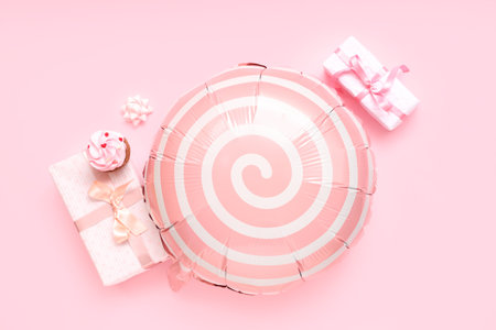 Balloon with gift boxes and cupcake on pink backgroundの写真素材