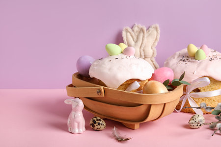 Composition with delicious decorated Easter cake and painted eggs in wooden basket on color backgroundの写真素材