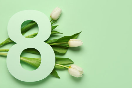 Figure 8 made of paper and beautiful white tulips on green background. International Women's Dayの写真素材