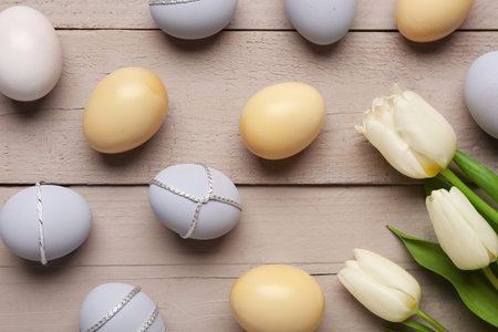 Beautiful tulip flowers and Easter eggs on gray wooden background