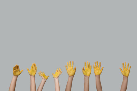 Children hands with yellow paint on gray background. International Childhood Cancer Dayの写真素材