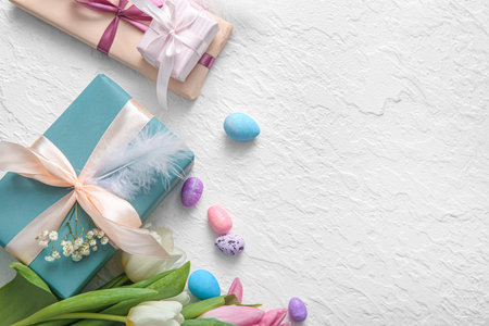 Easter eggs with gift boxes and flowers on white background