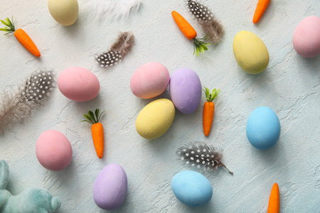 Painted Easter eggs with feathers and carrots on blue grunge backgroundの写真素材