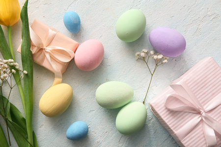 Painted Easter eggs with flowers and gift boxes on blue grunge backgroundの写真素材
