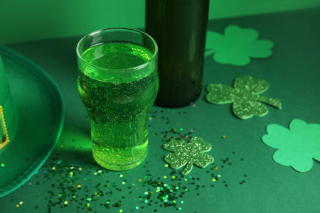 Glass and bottle of beer with clover on green background. St. Patrick's Day celebrationの写真素材