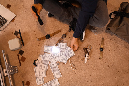 Male thief with flashlight and stolen money in room at night, top viewの写真素材