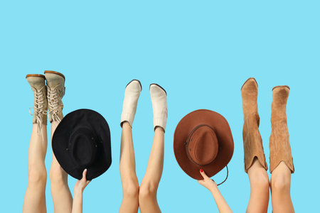Stylish women with different boots and hats on blue backgroundの写真素材