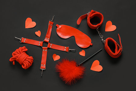 Composition with different sex toys and paper hearts on dark background. Valentine's Day celebrationの写真素材