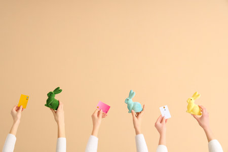 Women with credit cards and Easter rabbits on beige background. Online shoppingの写真素材