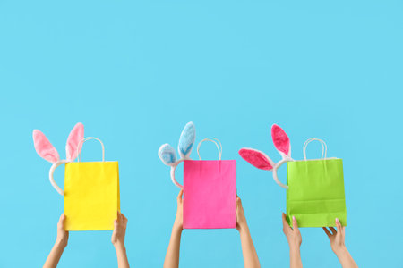 Women with shopping bags and bunny ears on blue background. Easter Saleの写真素材