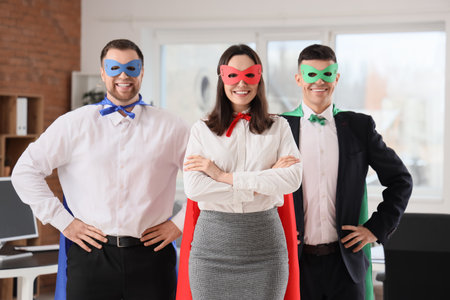 Business people dressed as superheroes in officeの写真素材