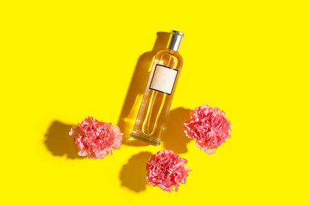 Bottle of perfume with flowers on yellow background. Top viewの写真素材