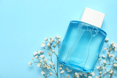 Bottle of perfume with gypsophila flowers on blue background. Top viewの写真素材