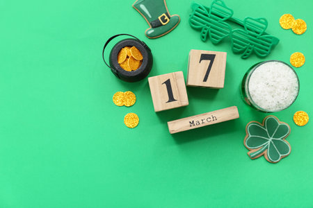 Cube calendar with date 17 MARCH, glass of beer, coins and sweet cookies on green background. St. Patrick's Day celebrationの写真素材