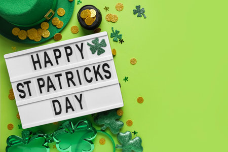 Board with words HAPPY ST PATRICKS DAY, leprechaun hat and decor on green backgroundの写真素材