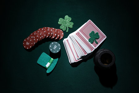 Poker chips, cards, pot with coins and lucky clovers on dark green background. St. Patrick's Day celebrationの写真素材