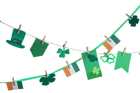 Paper garland with clover, leprechaun hat and Irish flags for St. Patrick's Day celebration on white backgroundの写真素材