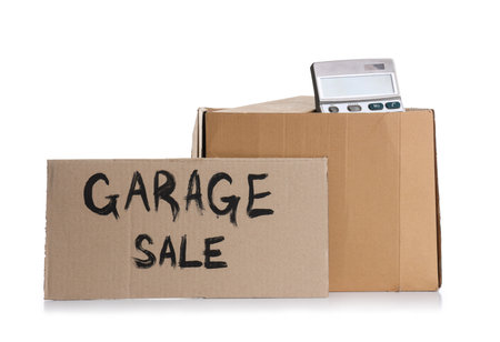 Box of unwanted stuff and cardboard with text GARAGE SALE on white backgroundの写真素材