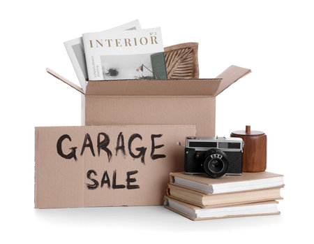 Box of unwanted stuff and cardboard with text GARAGE SALE on white backgroundの写真素材