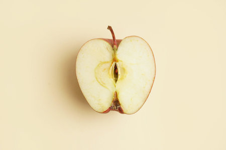 Half of fresh red apple on yellow background