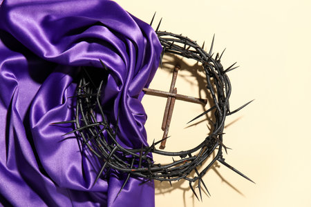 Crown of thorns with purple fabric and nails on beige backgroundの写真素材