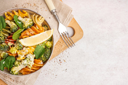 Delicious fusilli pasta with broccoli and lemon piece in bowl on light backgroundの写真素材