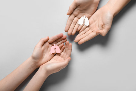 Hands of woman and child with paper lungs on gray backgroundの写真素材