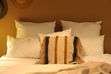 Bed with soft pillows in dark bedroom at night, closeupの写真素材