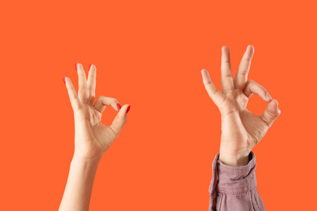 People showing OK on orange backgroundの写真素材