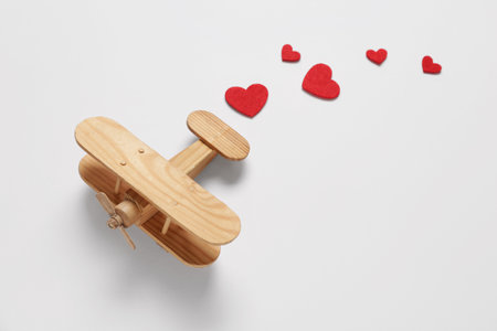 Wooden airplane with hearts on white background. Valentine's Day celebrationの写真素材