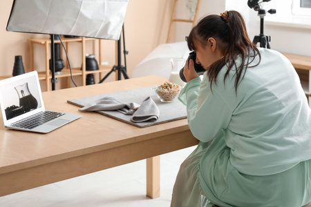 Female food photographer taking picture of tasty cereal rings with milk in studio