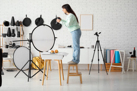 Female food photographer taking picture of cakes in studioの写真素材