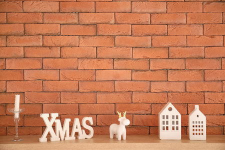 Shelf decorated for Christmas with candles against orange brick wallの写真素材