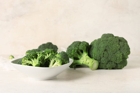 Bowl with fresh green broccoli on white grunge backgroundの写真素材