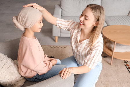 Little Asian girl after chemotherapy with her mother at homeの写真素材