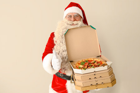 Santa Claus with boxes of tasty pizza showing thumb-up on white backgroundの写真素材