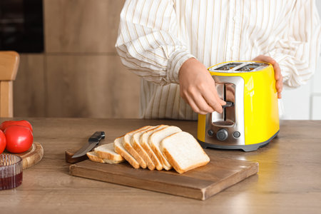 Young beautiful woman making tasty toasts in kitchen, closeupの写真素材
