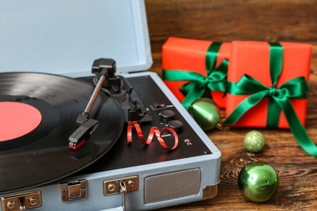 Vintage vinyl record player and Christmas gifts on wooden backgroundの写真素材
