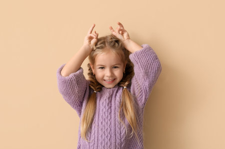 Happy little girl on beige backgroundの写真素材