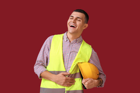 Portrait of happy male engineer laughing on red backgroundの写真素材