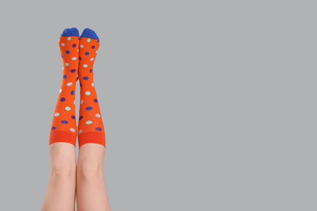 Legs of young woman in socks on gray backgroundの写真素材