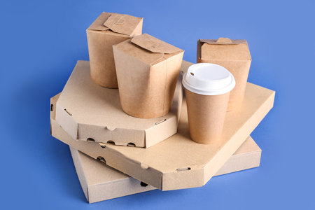 Takeaway paper cup and different boxes on blue backgroundの写真素材