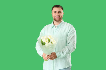 Handsome man with flowers on green backgroundの写真素材