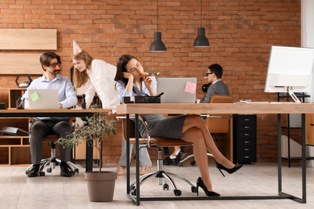 Sad business woman with party blower in office. April Fools' Day celebrationの写真素材