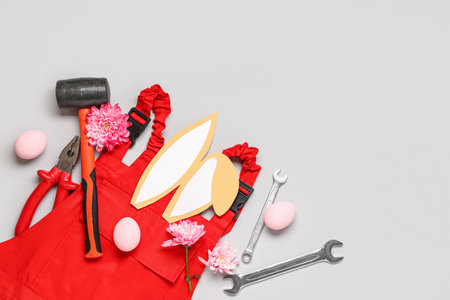 Composition with constructor's tools, uniform and Easter decor on gray backgroundの写真素材