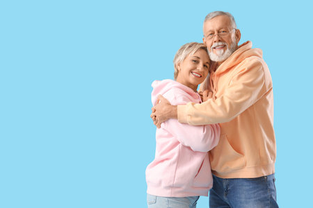 Mature couple hugging on blue background