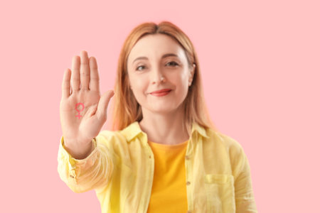 Mature woman with drawn gender symbol on pink background, closeupの写真素材