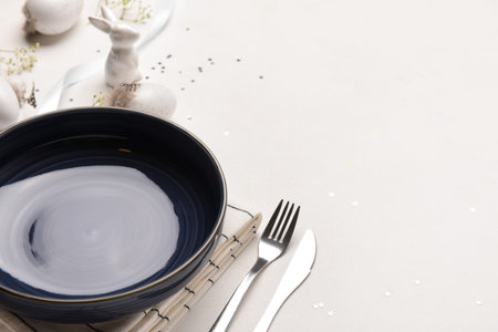Composition of festive Easter table setting served with eggs and flowers on white background