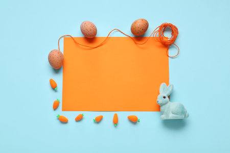 Painted eggs, Easter bunny and blank card on blue background. Top viewの写真素材