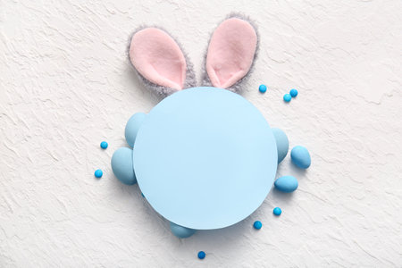 Bunny ears with Easter eggs and blank greeting card on white grunge backgroundの写真素材